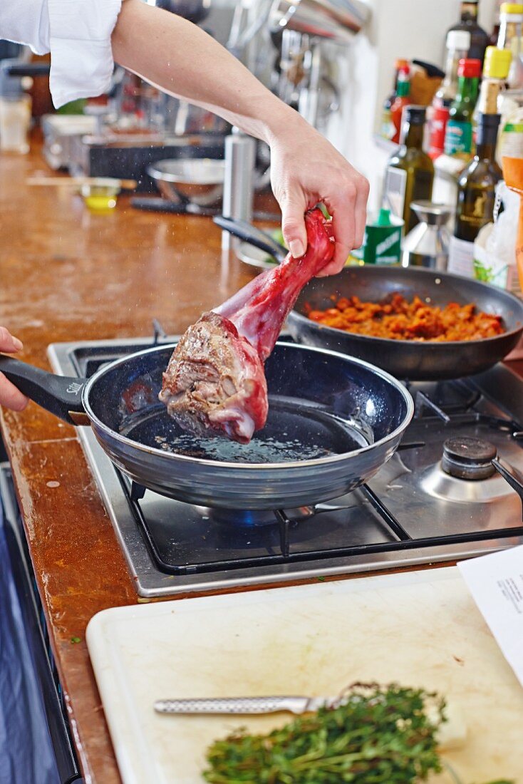 Lamb shoulder being browned in a pan