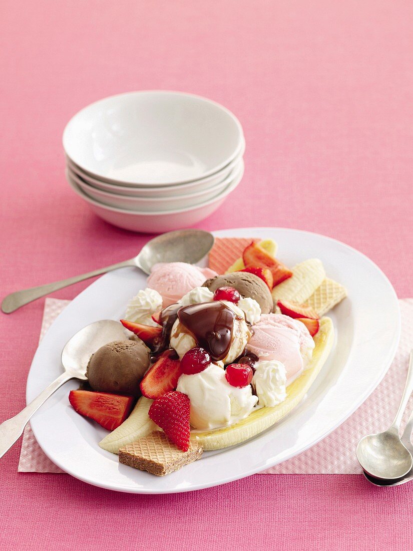 Neapolitan ice cream dessert with banana, strawberries and wafers