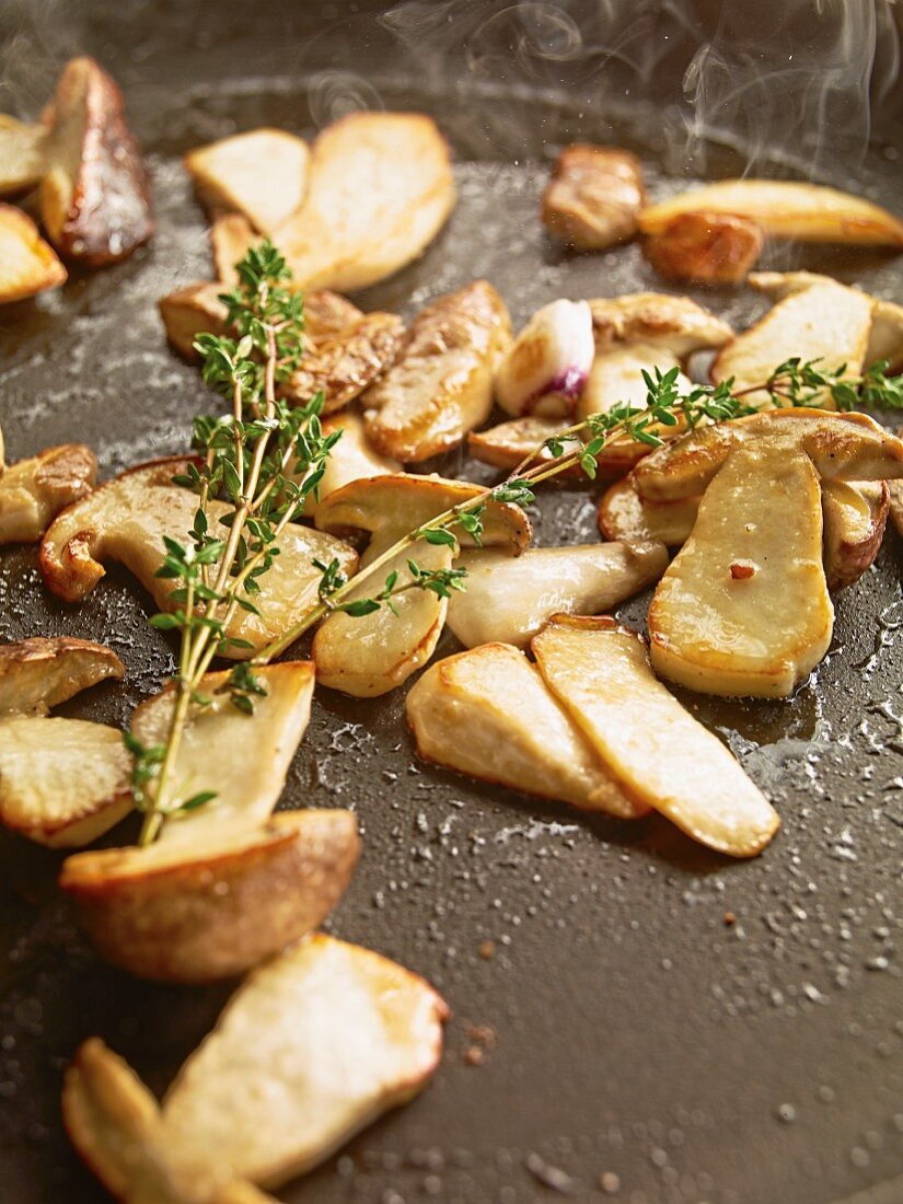 Fried porcini mushrooms with thyme in a pan
