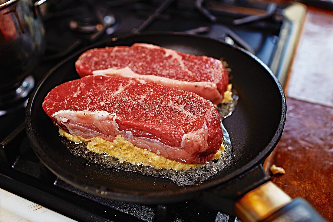 Beef steaks being seared in a pan