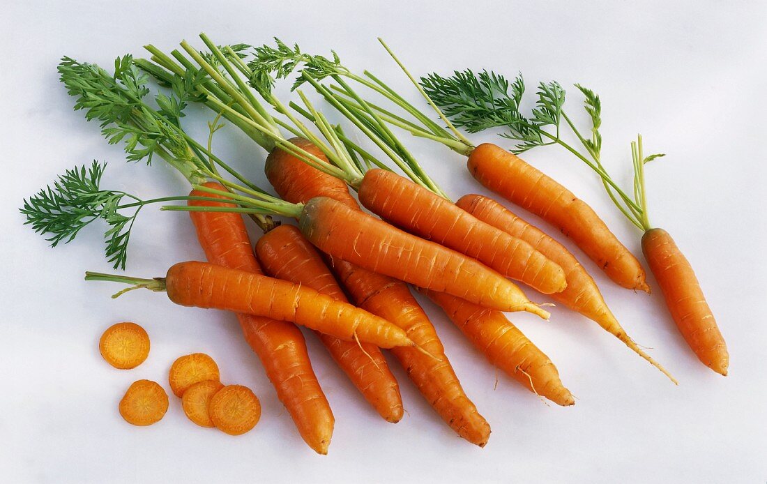Several whole carrots and slices of carrot
