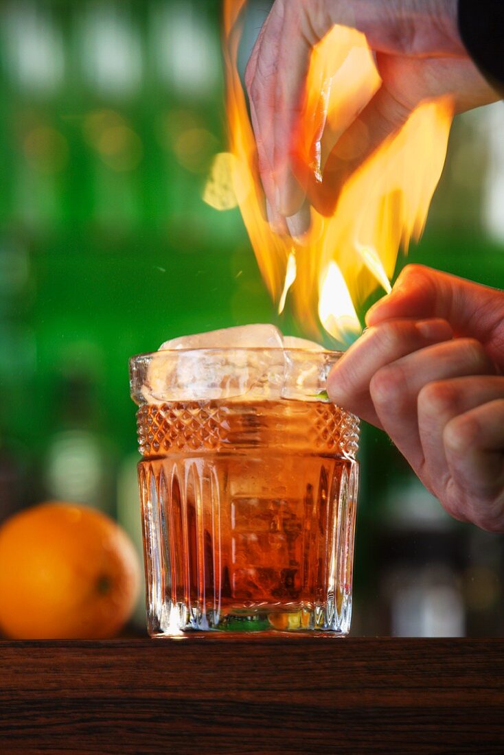 A flaming cocktail with orange