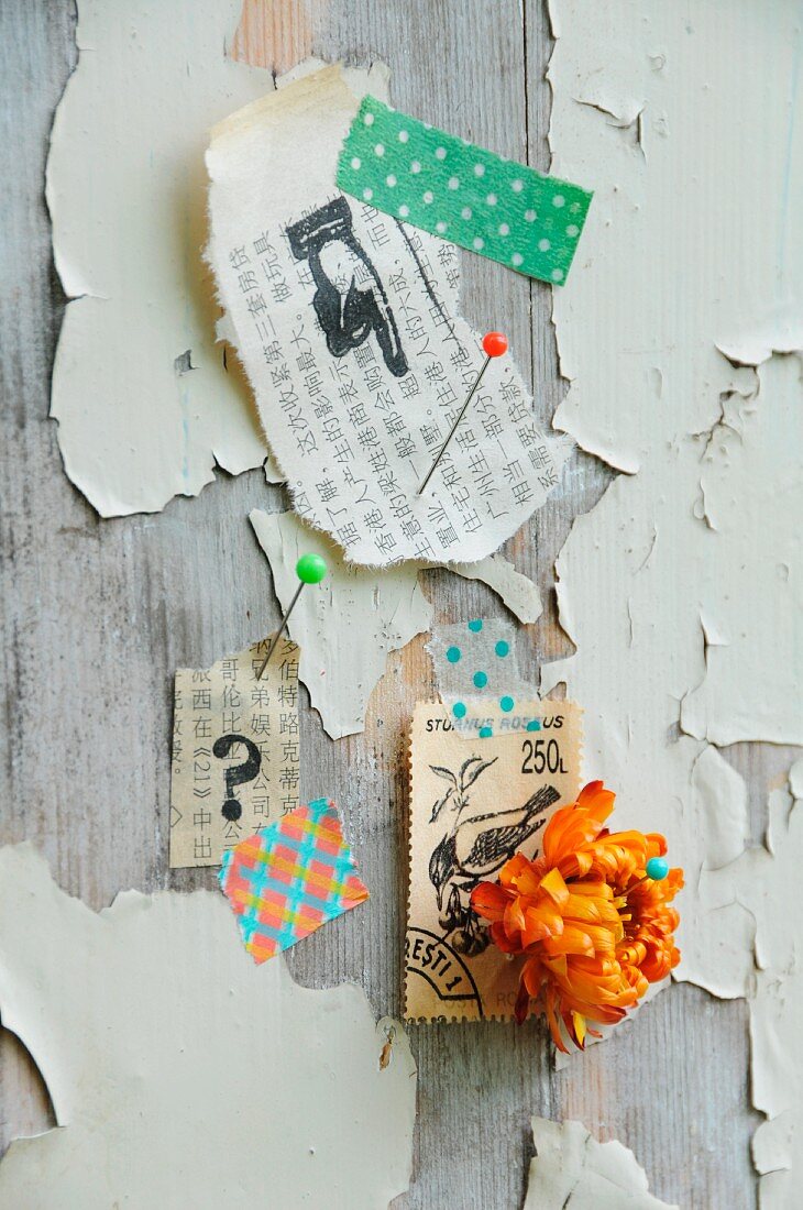 Pinwand mit Briefmarke, Strohblume, bedrucktem Asiapapier und Masking Tape als Wanddeko auf Holz mit extremer Patina