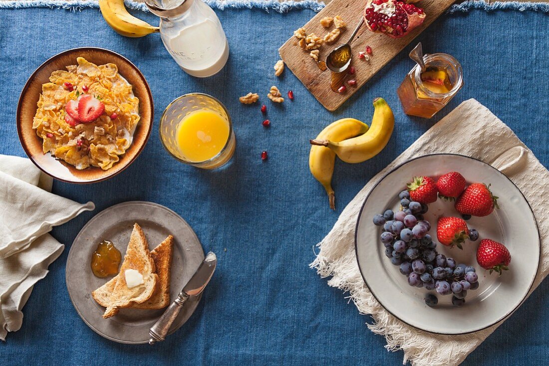 Frühstück mit Müsli, Obst, Toast und Orangensaft