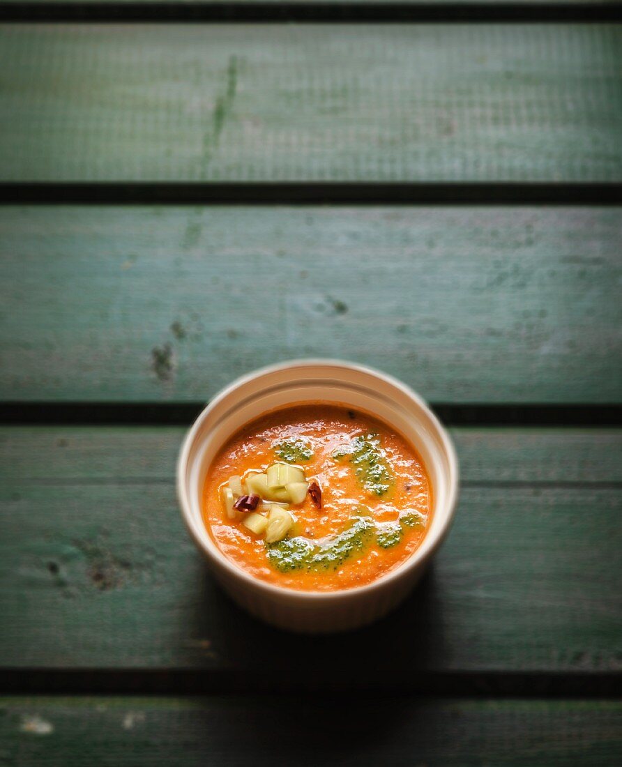 Gazpacho garnished with Cilantro Oil, Chopped Cucumbers and Dried Chili Peppers