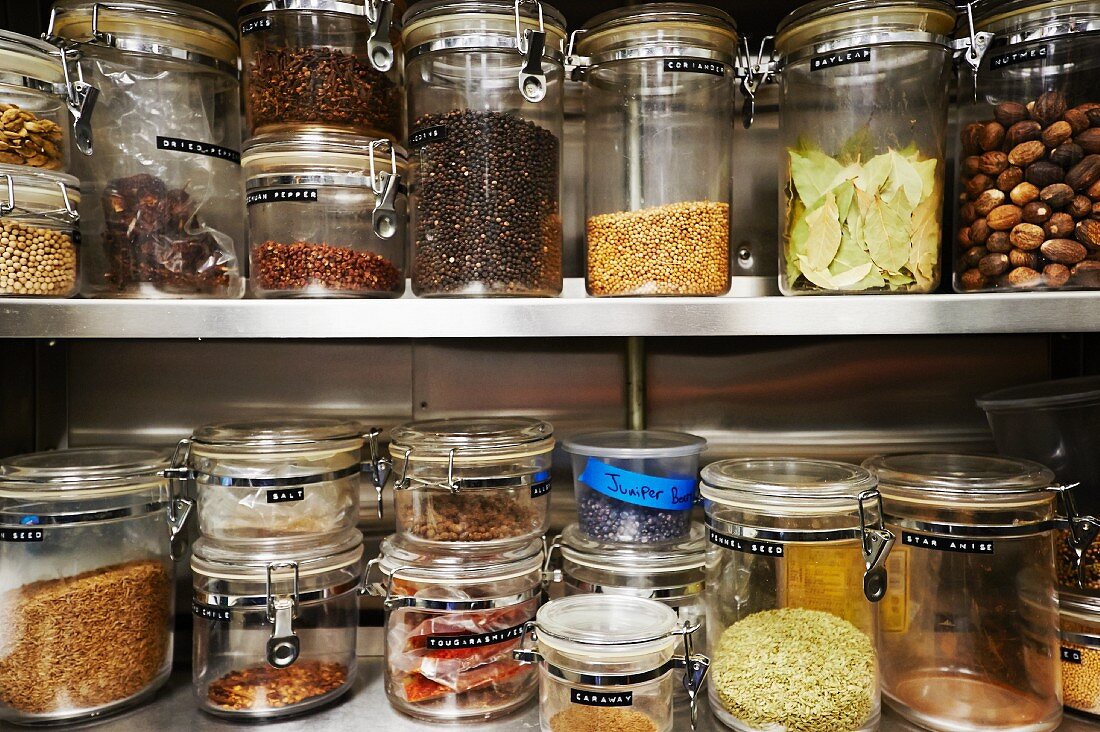 Assorted Dried Ingredients in Storage Containers on Metal Shelves
