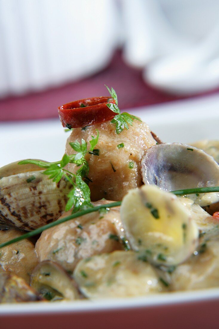 Seeteufelbällchen mit Venusmuscheln in Kräutersauce