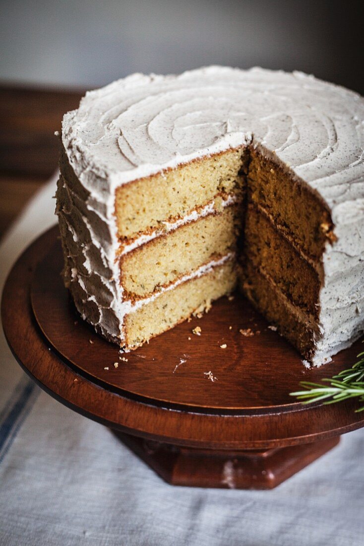 Rosemary Corn Cake with Brown Butter and Honey Buttercream Frosting on a Wooden Cake Plate