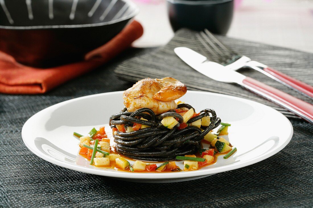 Black spaghetti with scallops, vegetables and sobrasada