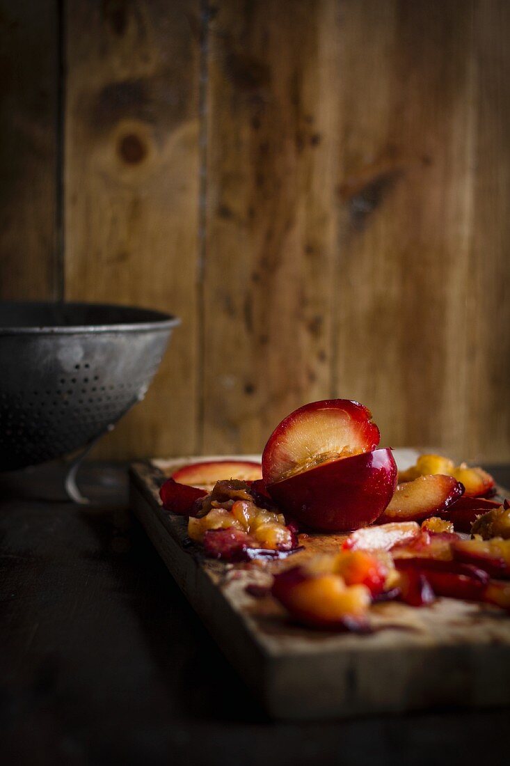 Preparing Red Plums on a Wooden Cutting Board