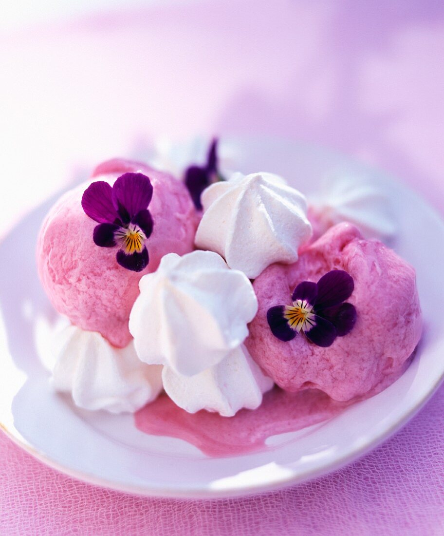 Raspberry ice cream with mini meringues and pansies