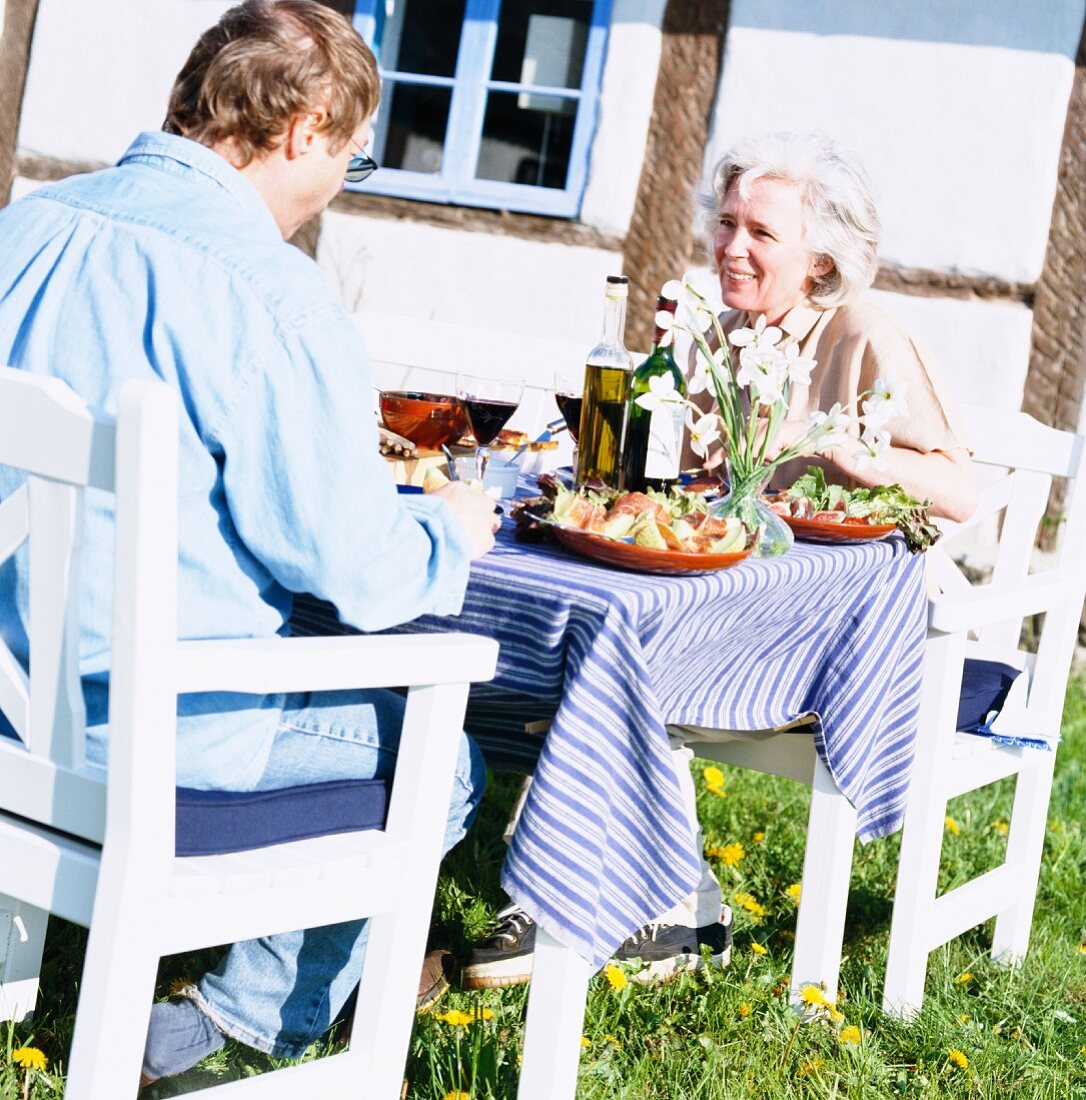 A couple eating lunch in the garden, Skane, Sweden.