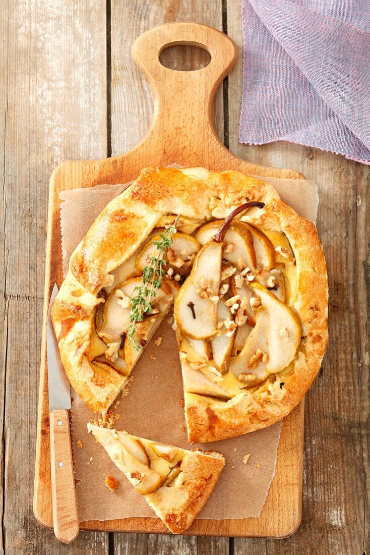 Pear tart with walnuts, one slice cut