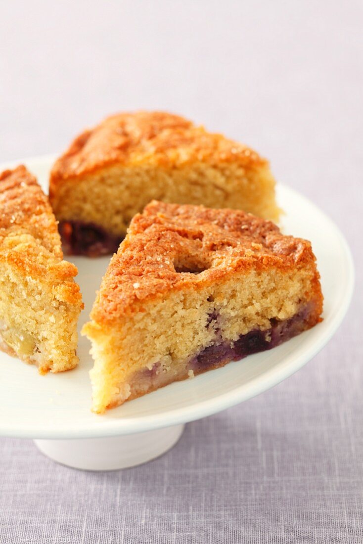 Three slices of grape cake on a cake stand