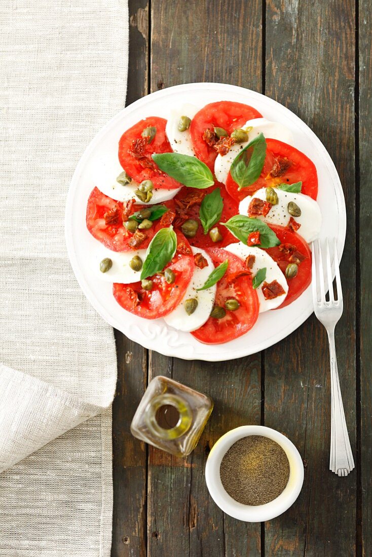 Tomatoes with mozzarella, basil and capers