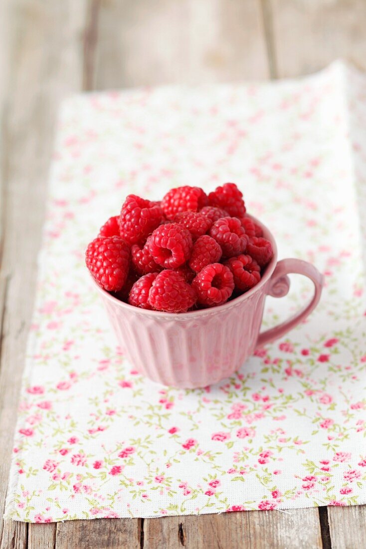 Himbeeren in einer rosa Tasse