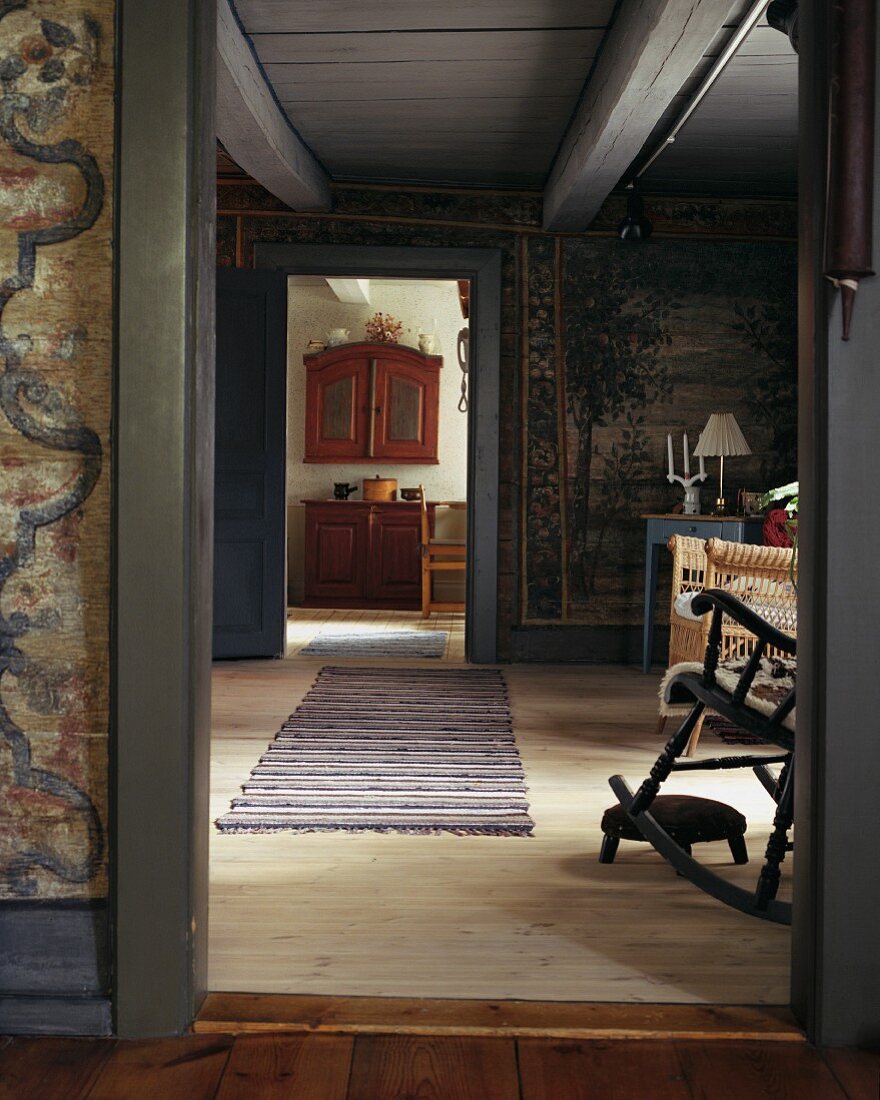 Blick durch offene Tür in schlichtes Wohnzimmer eines skandinavischen Landhauses