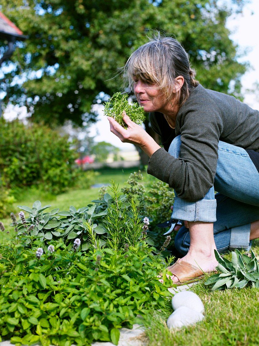 Woman smelling herbs in garden