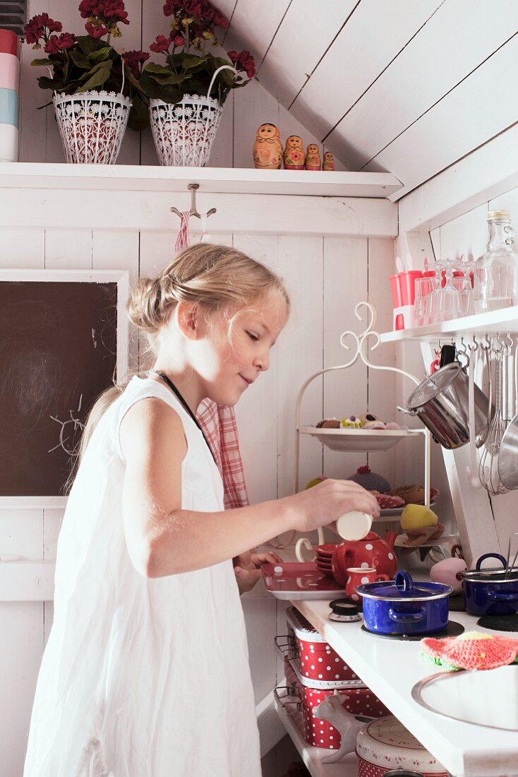 Blondes Mädchen beim Kochen in einem Spielhaus