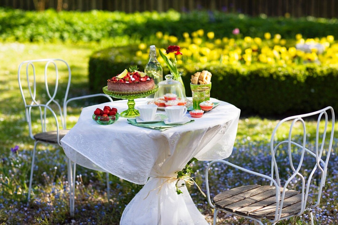 Table in a garden ready laid with strawberry cake, Sweden.
