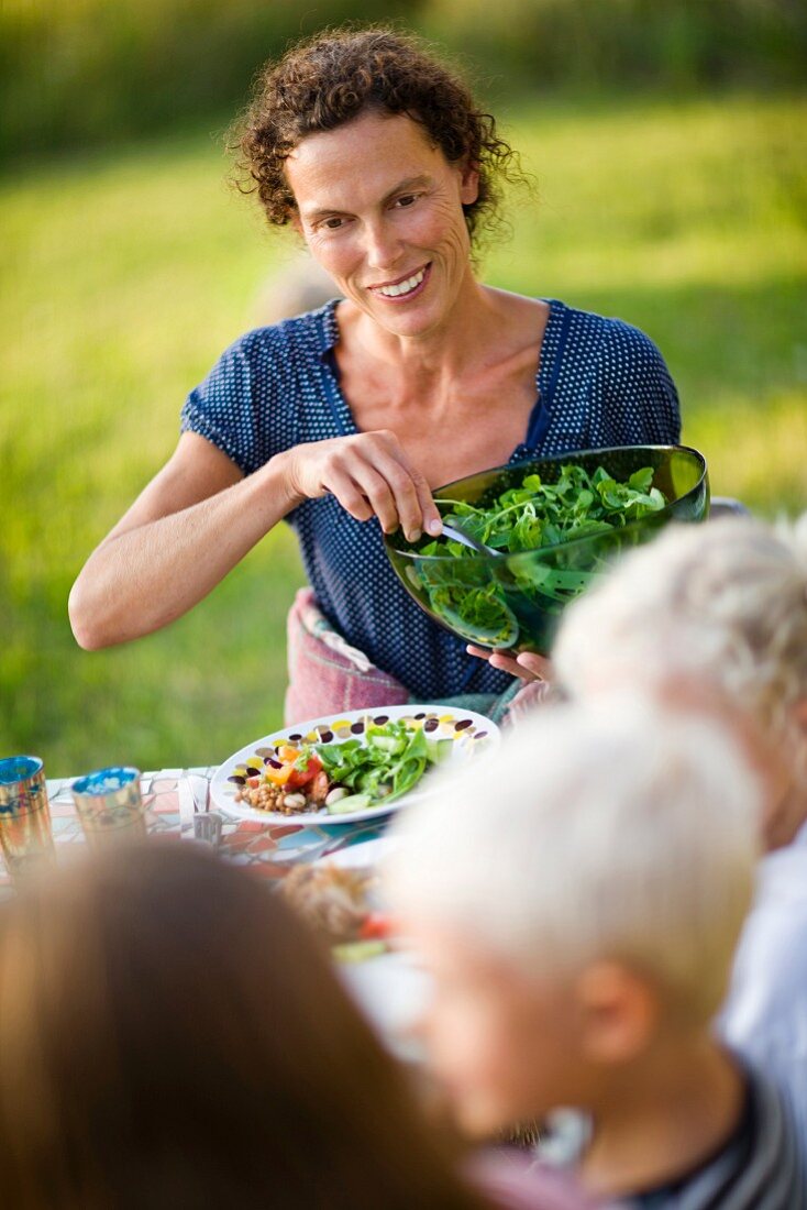 Woman serving vegetable salad
