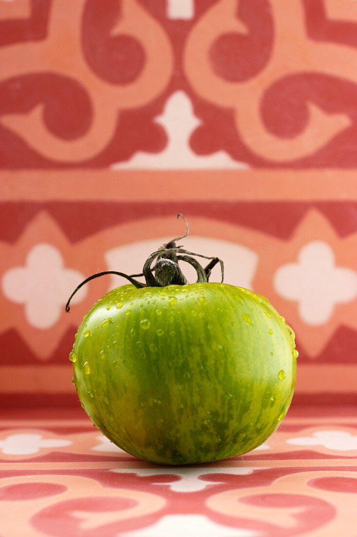 Eine grüne Tomate mit Wassertropfen