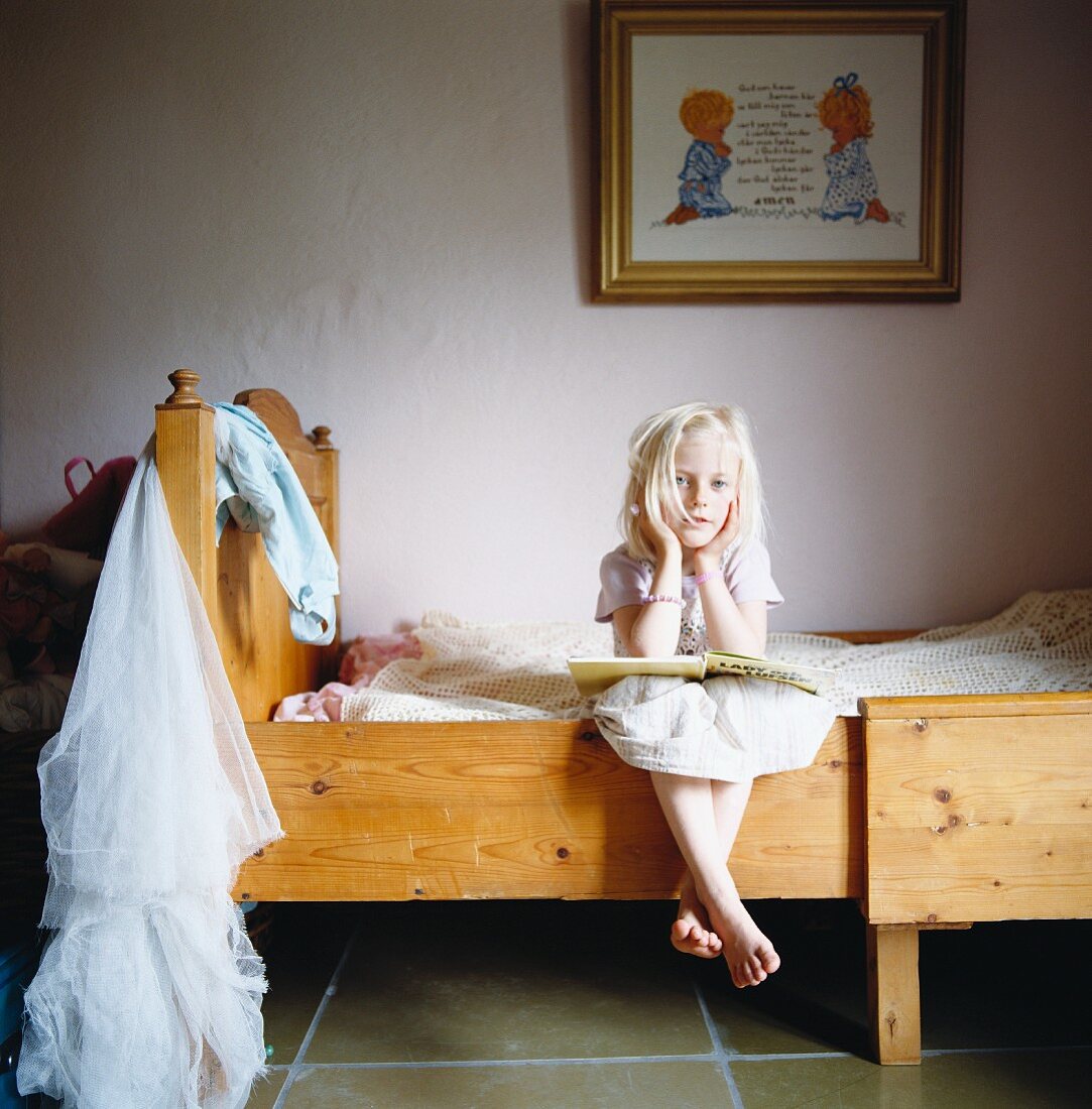 Portrait of a blond girl sitting in a bed, Sweden