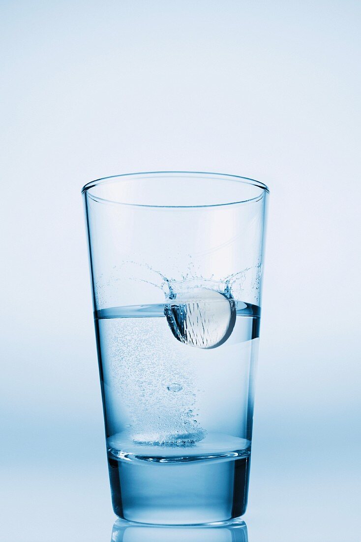 Tablette fällt in ein Glas Wasser