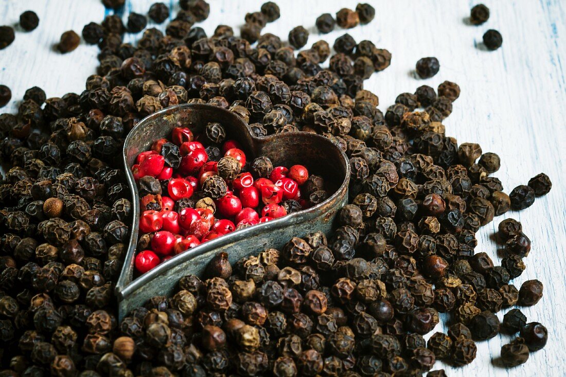 Red and black peppercorns with a cutter