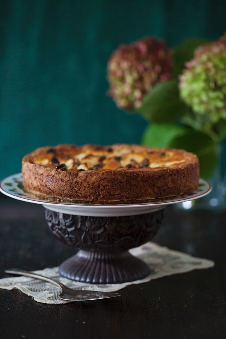 Apfelkuchen mit Rosinen auf einem Tortenständer