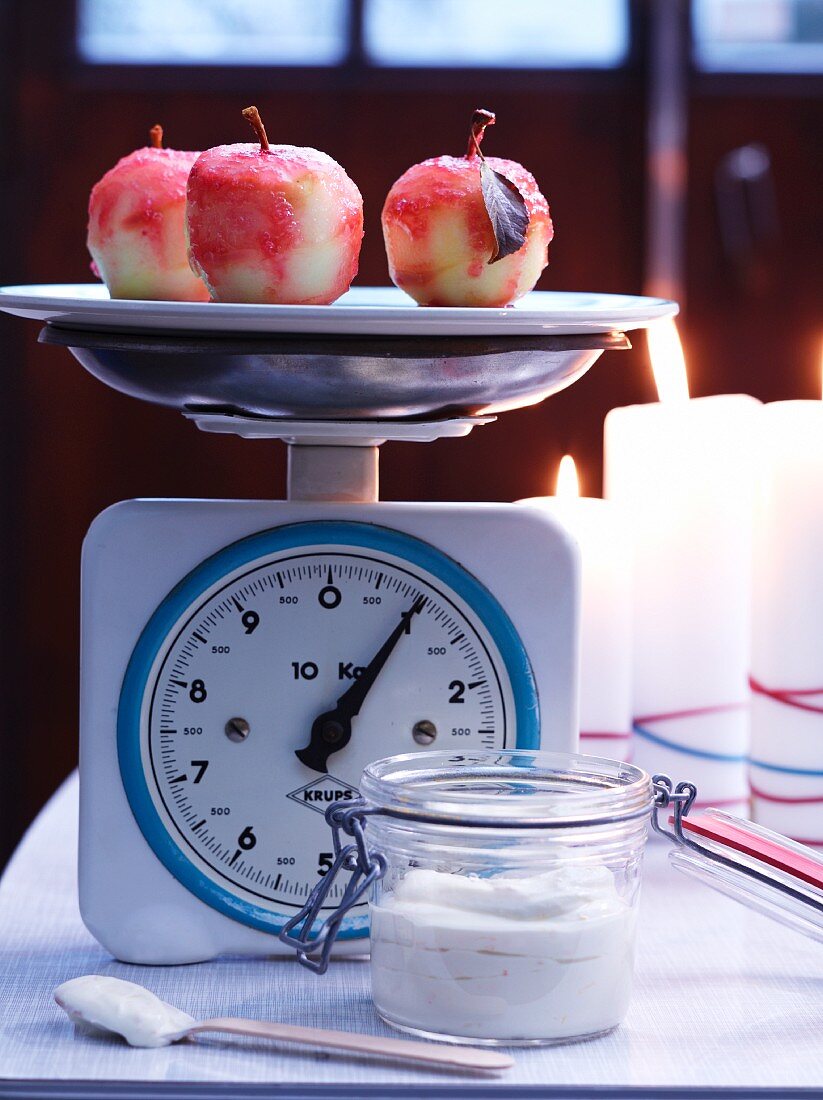 Candy apples on kitchen scales with mascarpone cream