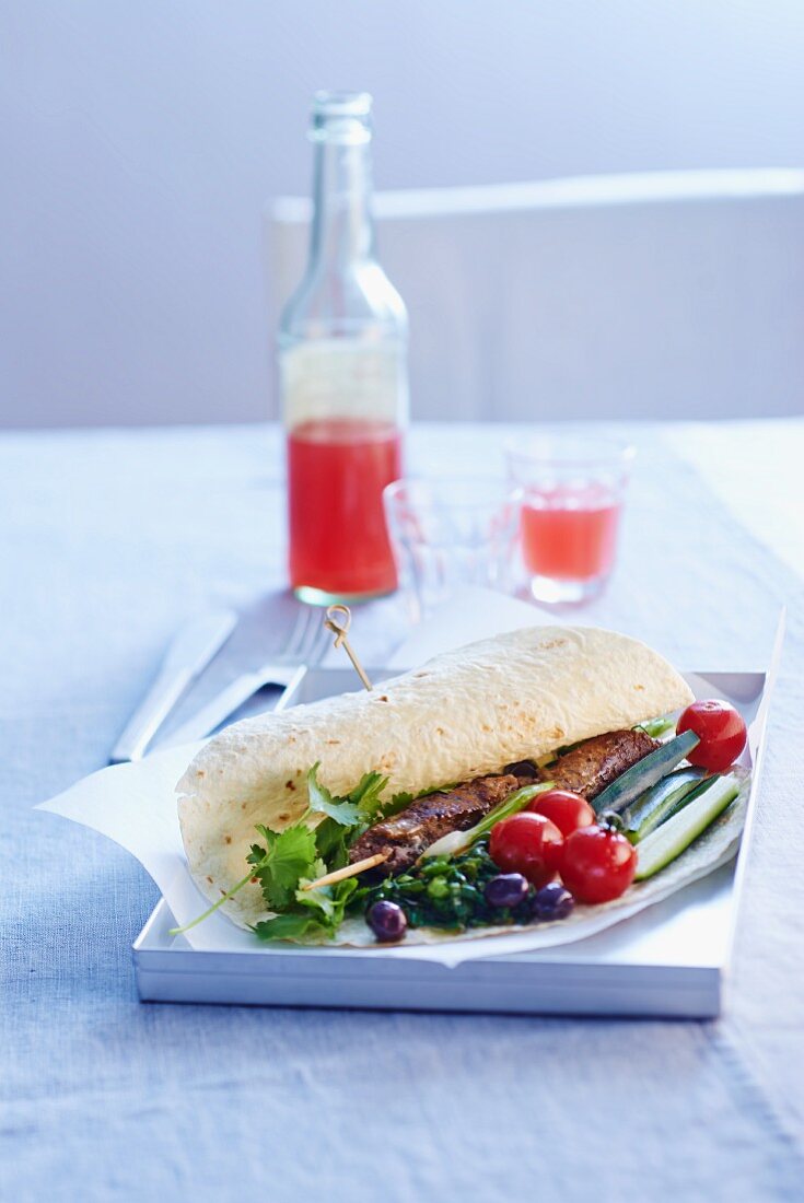 Wrap with a beef skewer, cherry tomatoes and olives