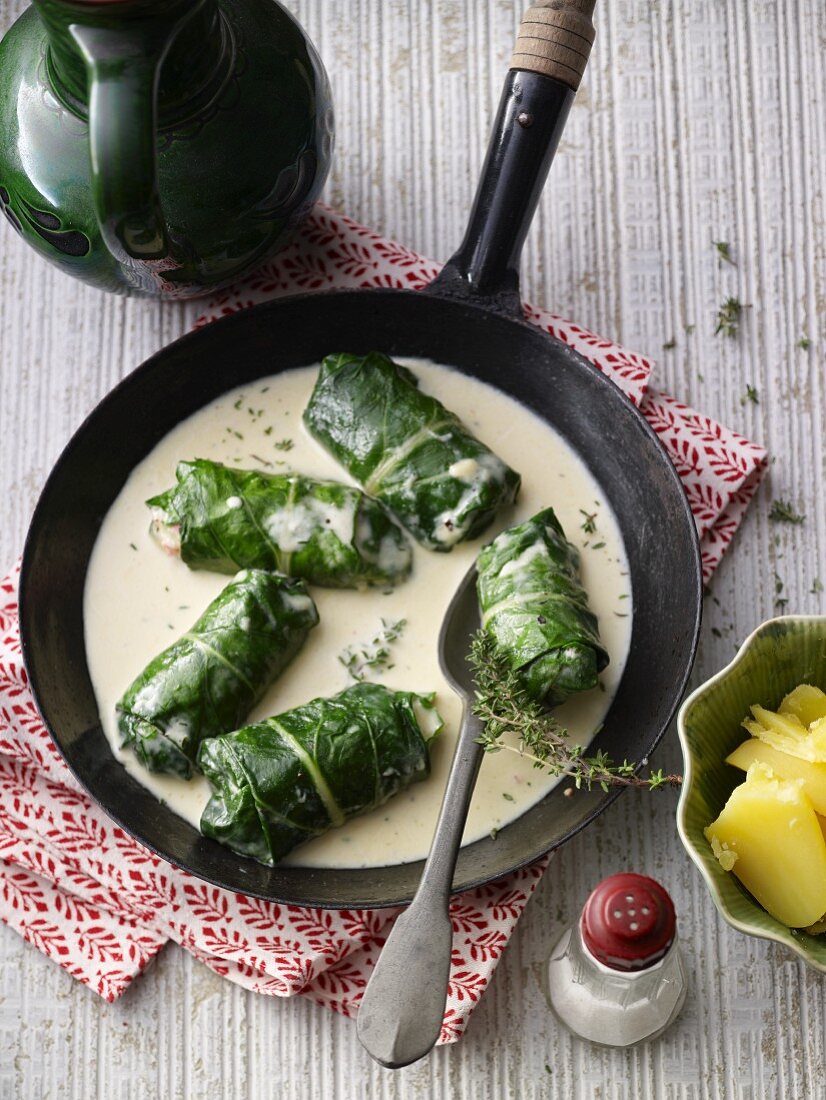 Capuns (stuffed chard leaves, Graubünden) in white sauce with a side of potatoes