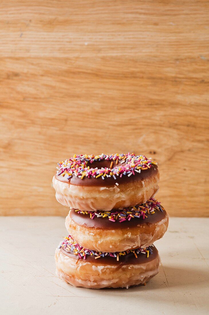 Drei Donuts mit Schokoglasur & bunten Zuckerstreuseln