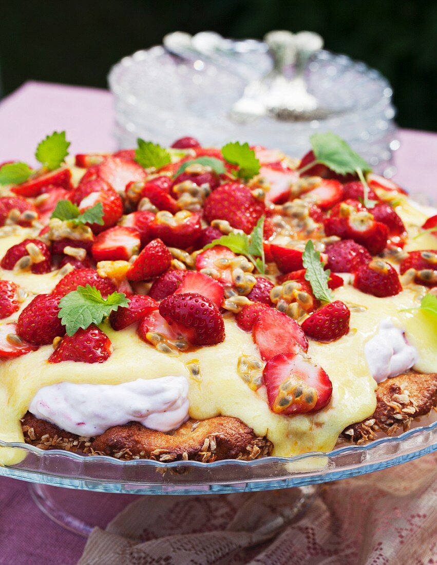 Erdbeerkuchen mit Vanillesauce auf Gartentisch