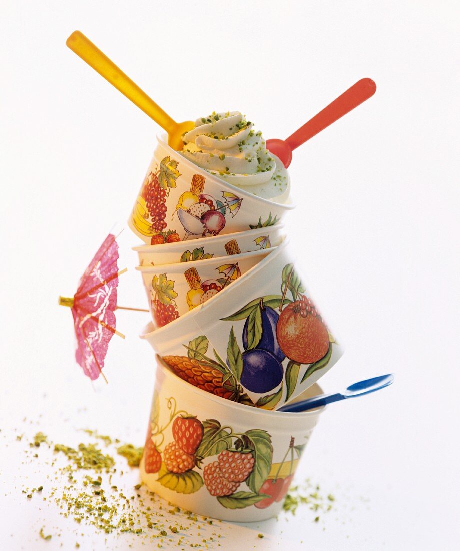 Stacked ice cream cups decorated with a fruit design, with a cocktail umbrella