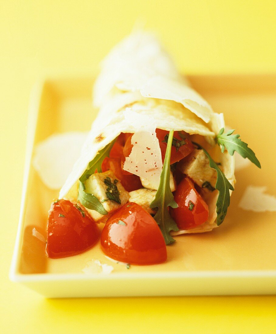 A wrap filled with tomatoes, avocado, parmesan and rocket