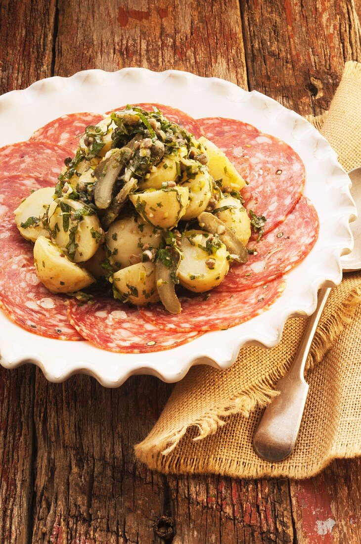 Potato salad with herb dressing, served on slices of salami