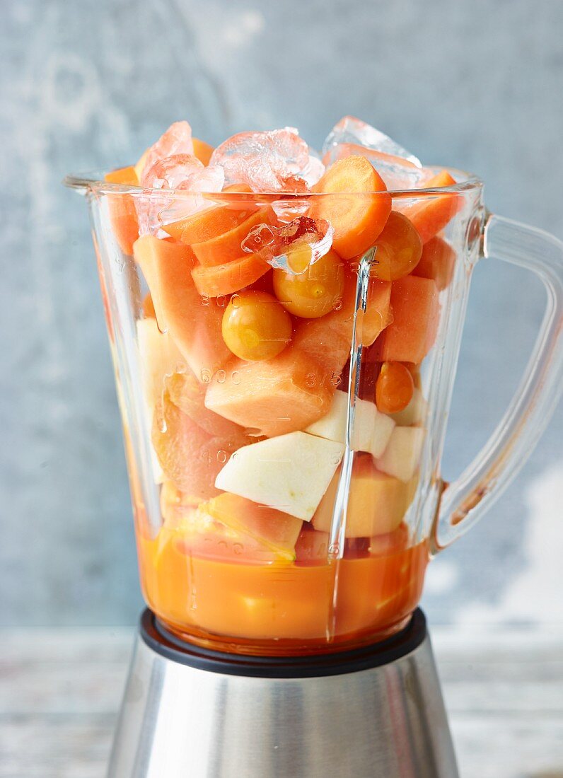 Zutaten für Melonen-Ingwer-Smoothie und Mango-Clementinen-Smoothie im Mixer