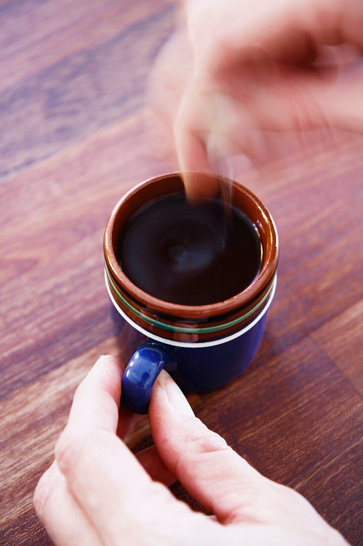 Frau rührt Kaffee in der Tasse um