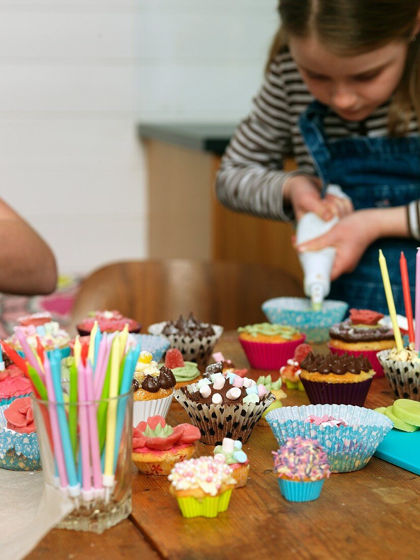 Mädchen beim Muffins verzieren