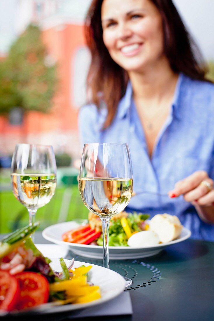 Frau isst Salat im Strassencafe