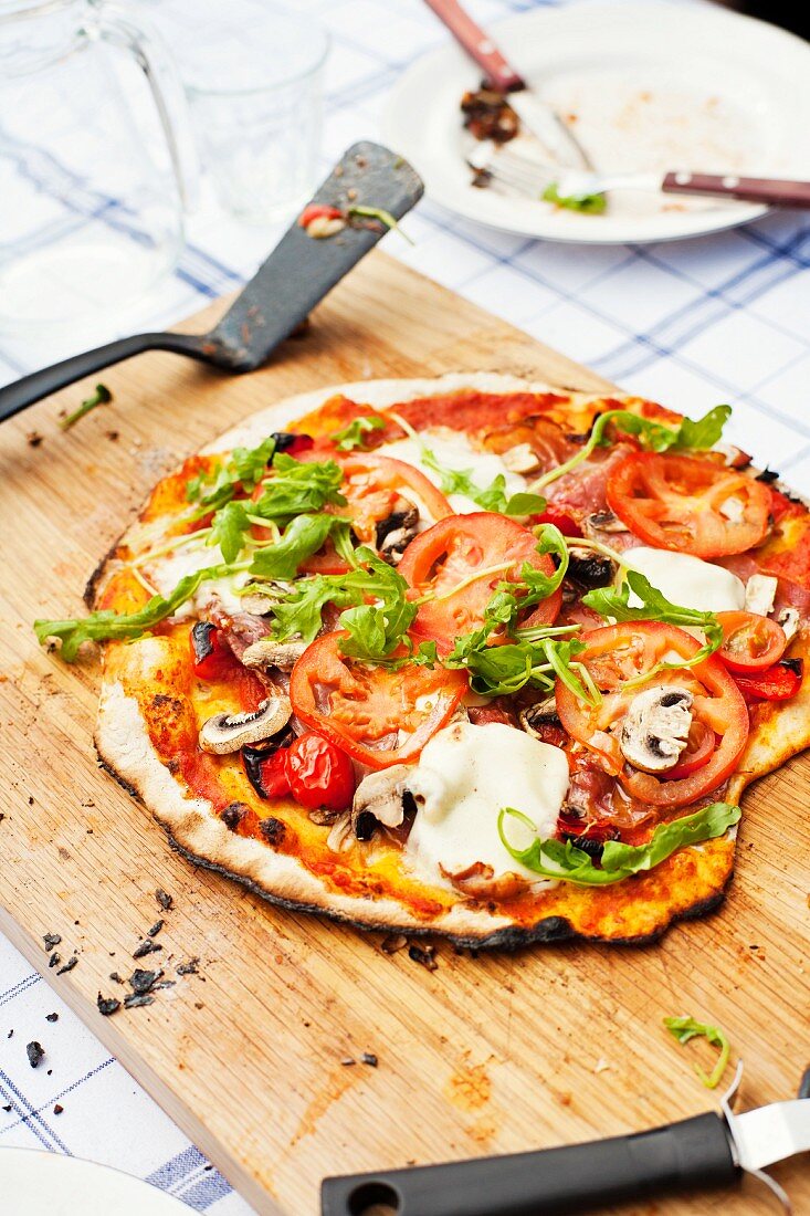 Hausgemachte Pizza mit Tomaten, Mozzarella und Champignons