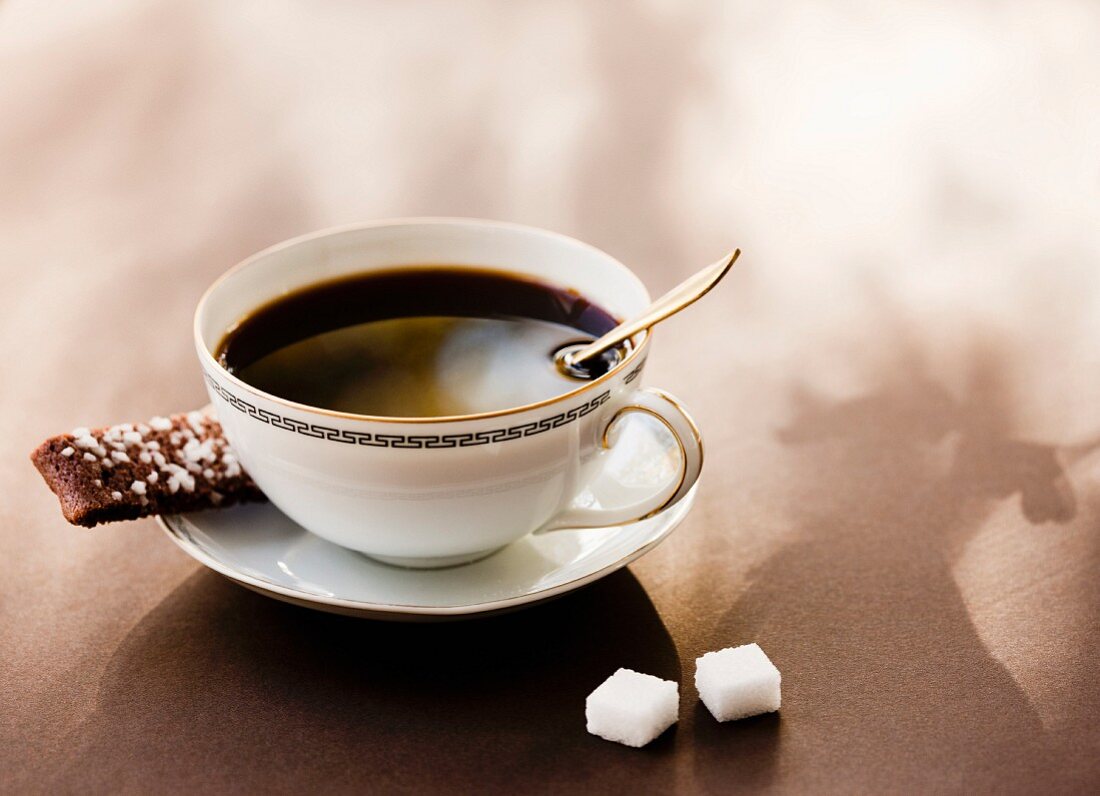 High angle view of black coffee with coffee cookie