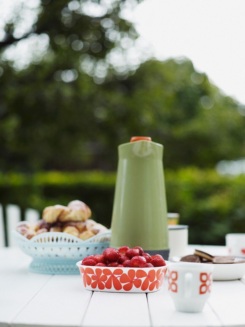 Erdbeeren, Kaffee und Plätzchen auf Gartentisch