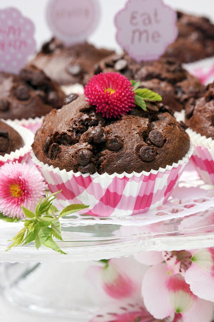 Chocolate muffins on glass cake stand decorated with flowers