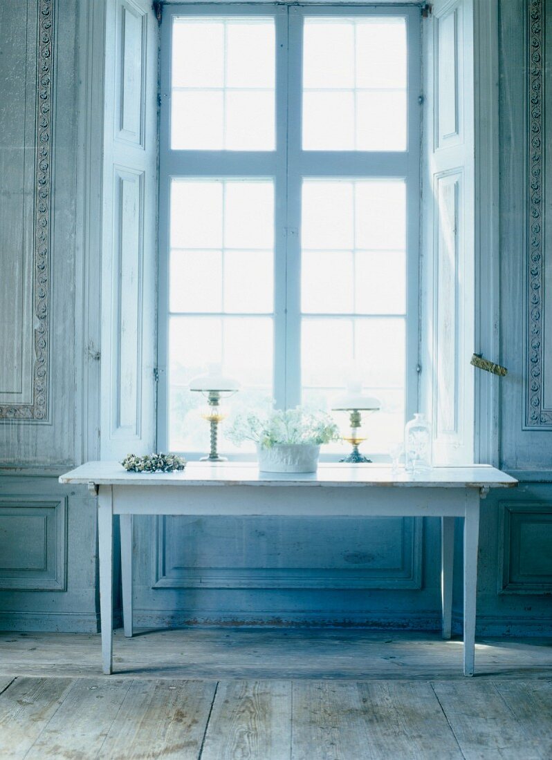 Schlichter Wandtisch vor hohem Fenster in herrschaftlichem Zimmer