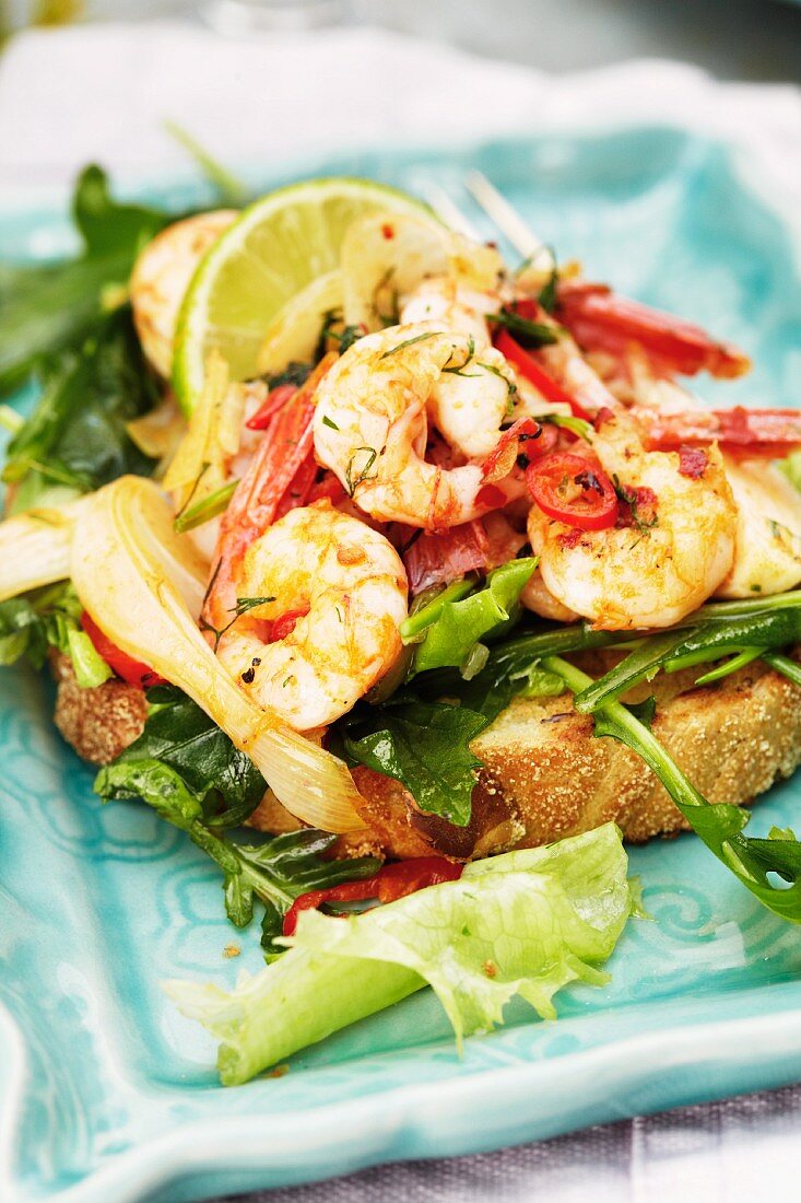 Chilli prawns with rocket and lime wedges on toast