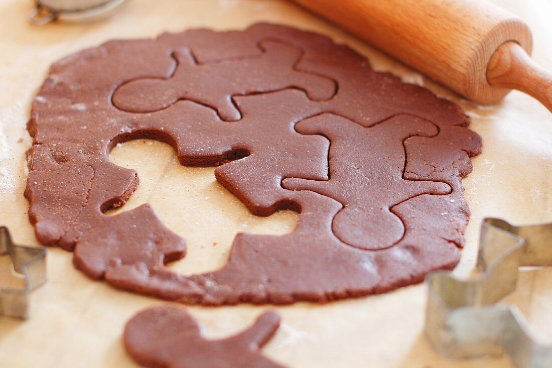 Gingerbread dough with one biscuit cut out and removed