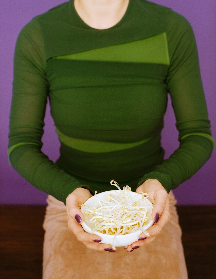 A woman holding a bowl of beansprouts